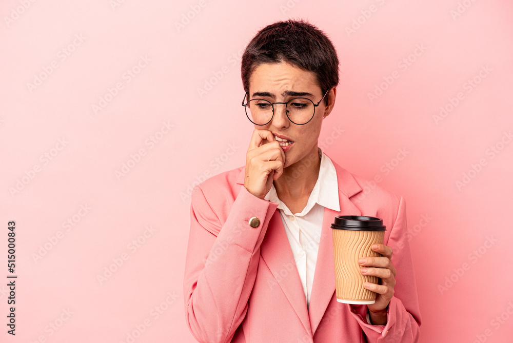 Young caucasian business woman holding a takeaway coffee isolated on pink background relaxed thinking about something looking at a copy space.