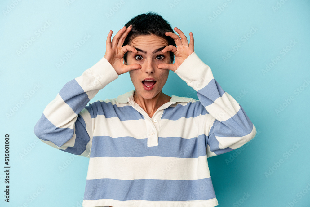 Young caucasian woman isolated on blue background keeping eyes opened to find a success opportunity. Young caucasian woman isolated on blue background keeping eyes opened to find a success opportunity.