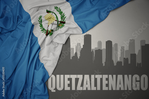 abstract silhouette of the city with text Quetzaltenango near waving national flag of guatemala on a gray background. 3D illustration photo