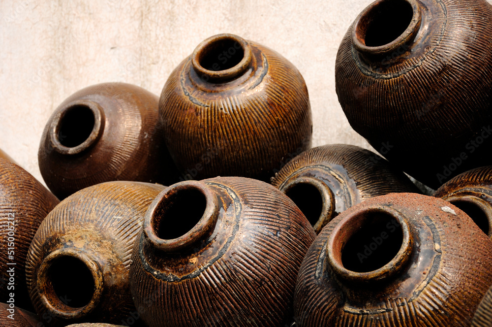 Traditional ceramic jars used to make Xuchang famous soy sauce stacked up against a  wall in Tongxiang's Wuzhen Scenic Area in Zhejiang province China.