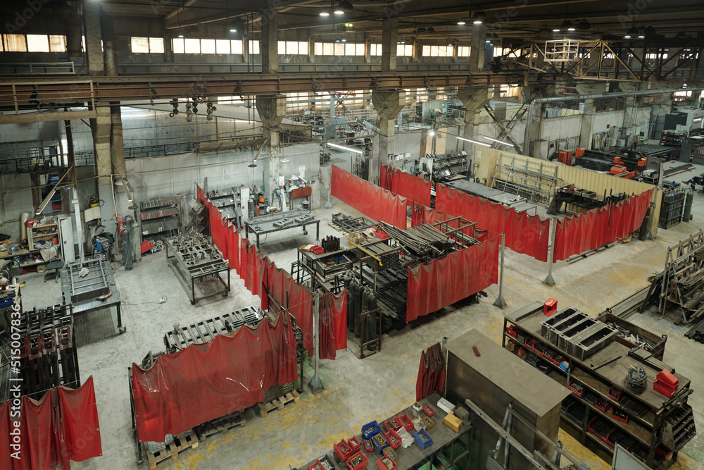 View of part of large industrial plant of modern factory with group of workshops divided by red curtains from each other