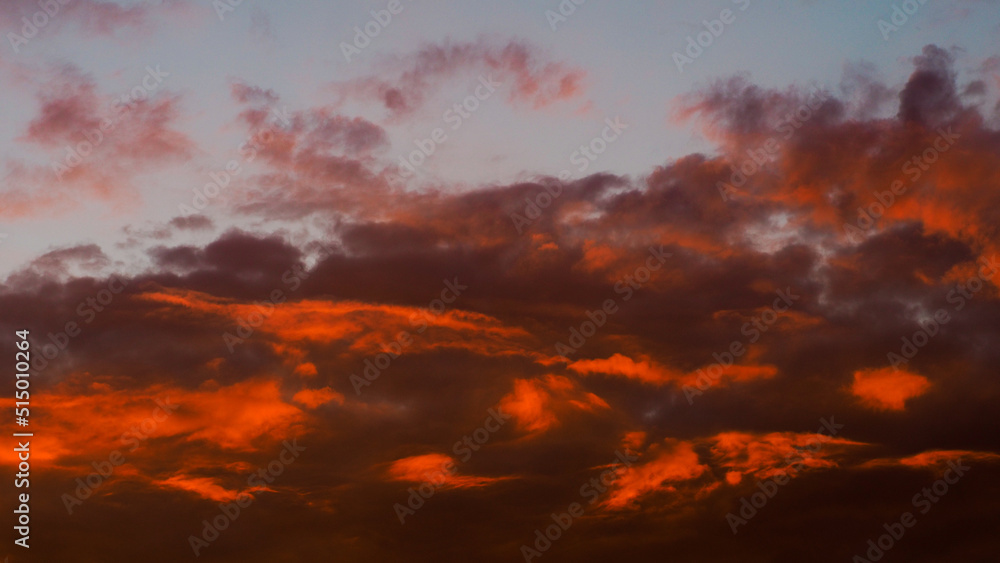 Ciel rougeoyant sous des nuages de haute altitude, pendant le crépuscule