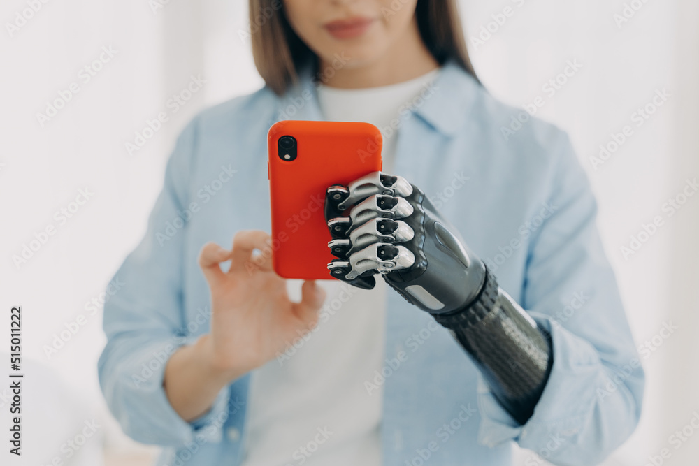Hands of young european woman with smartphone. Girl holding the phone with bionic arm and texting. Hands of young european woman with smartphone. Girl holding the phone with bionic arm and texting.