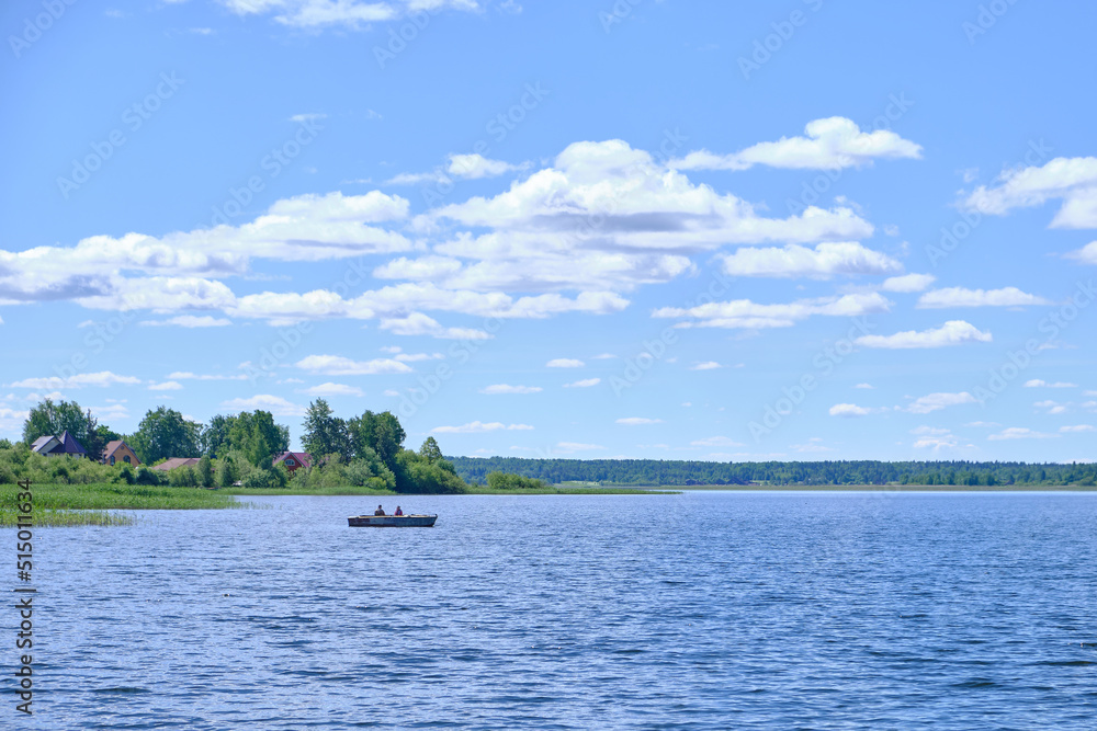 Fishermen in a boat on the lake, sunny day