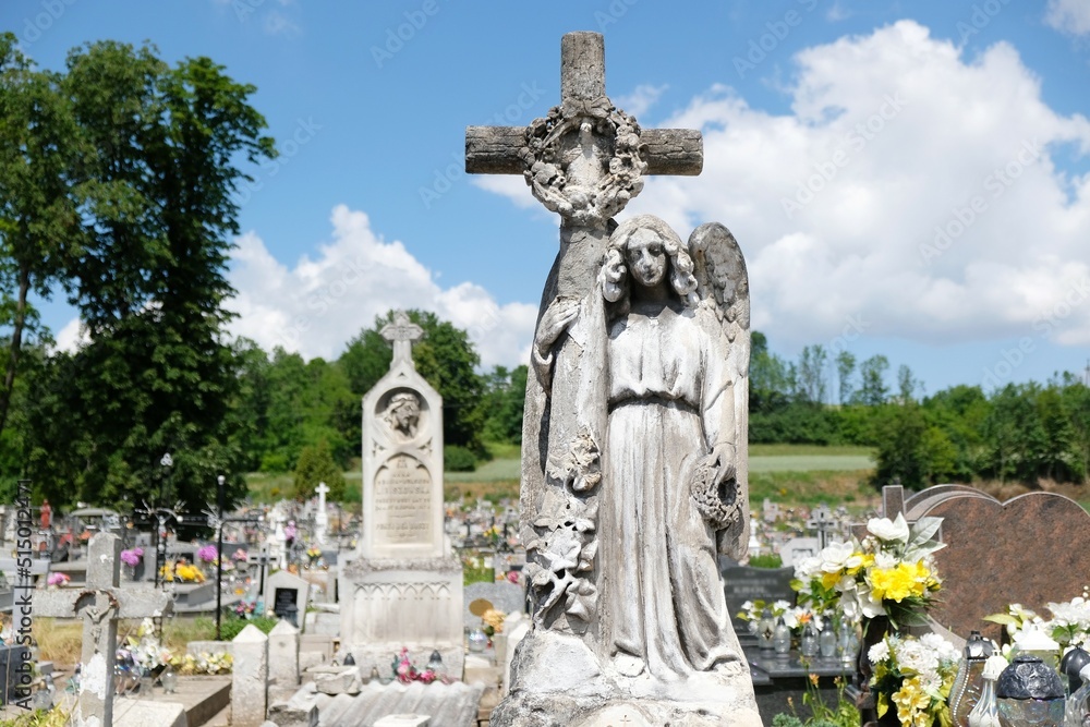 Figure of angel with cross at cemetery in Pelczyska, Ponidzie, Swietokrzyskie, Poland. The sculpture is made of Pinczow limestone (pinczak).