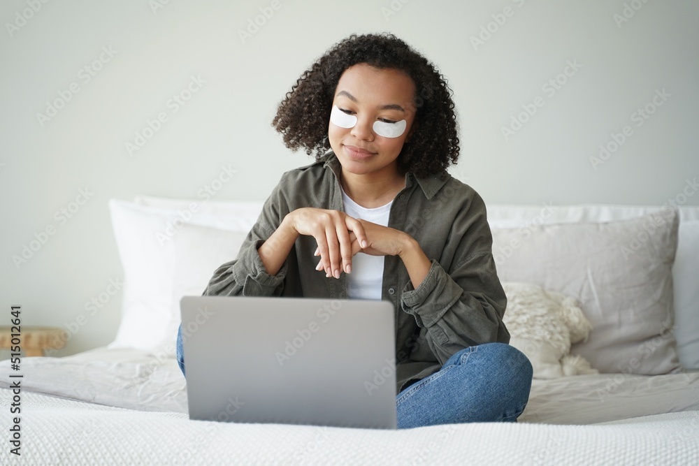 Happy afro girl applies eye patches and relaxing at home watching tv series. Weekend morning. Happy afro girl applies eye patches and relaxing at home watching tv series. Weekend morning.