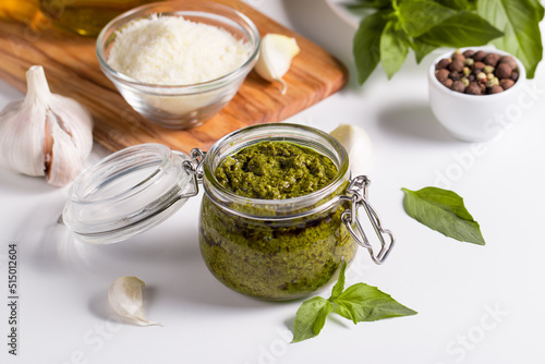 Basil pesto sauce in a jar. Ingredients for cooking, cheese, parmesan, garlic, olive oil. 