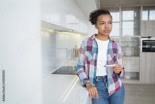 Fototapete Pensive teenage girl gets positive pregnancy test result