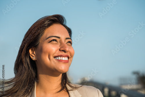 Close-up of a Latina woman smiling sideways. Copy space
