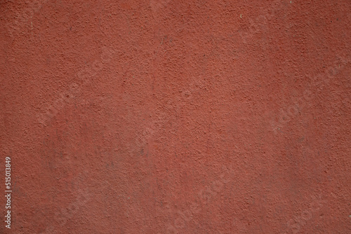 Red colored wall rough grainy cemented texture background