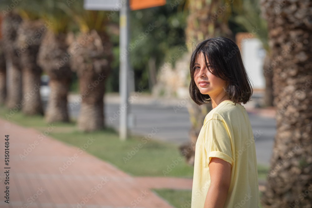 A teenage girl walking down the sidewalk turned around and looked at the camera. A teenage girl walking down the sidewalk turned around and looked at the camera.