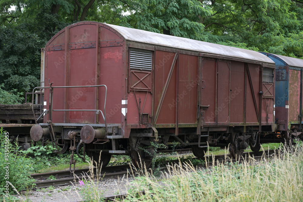Old rusty freight wagon on the siding on overgrown railroad tracks, transportation concept, copy space Old rusty freight wagon on the siding on overgrown railroad tracks, transportation concept, copy space