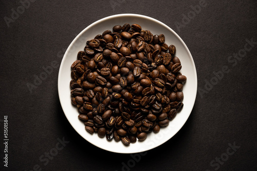 closeup of roasted coffee beans on white plate © Pablo
