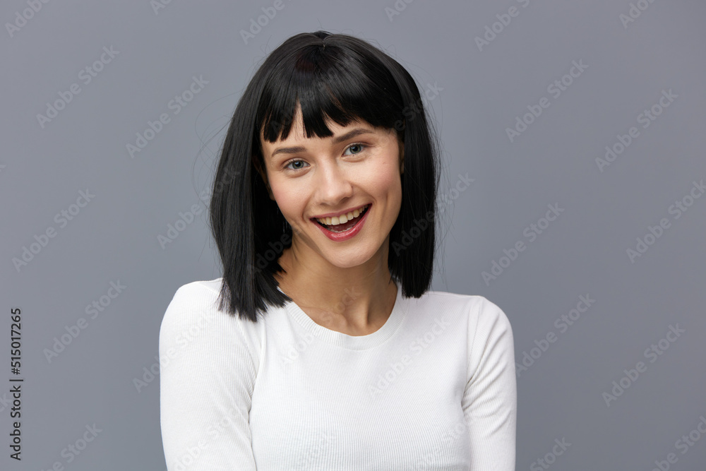 a happy woman stands on a dark background in a tight white T-shirt, slightly tilted her head back, calmly lowering her hands down a happy woman stands on a dark background in a tight white T-shirt, slightly tilted her head back, calmly lowering her hands down