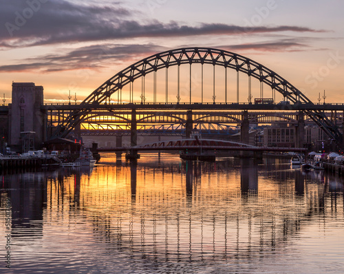 Fototapeta Naklejka Na Ścianę i Meble -  The Tyne Bridge in Newcastle at sunset, reflecting in the almost still River Tyne beneath