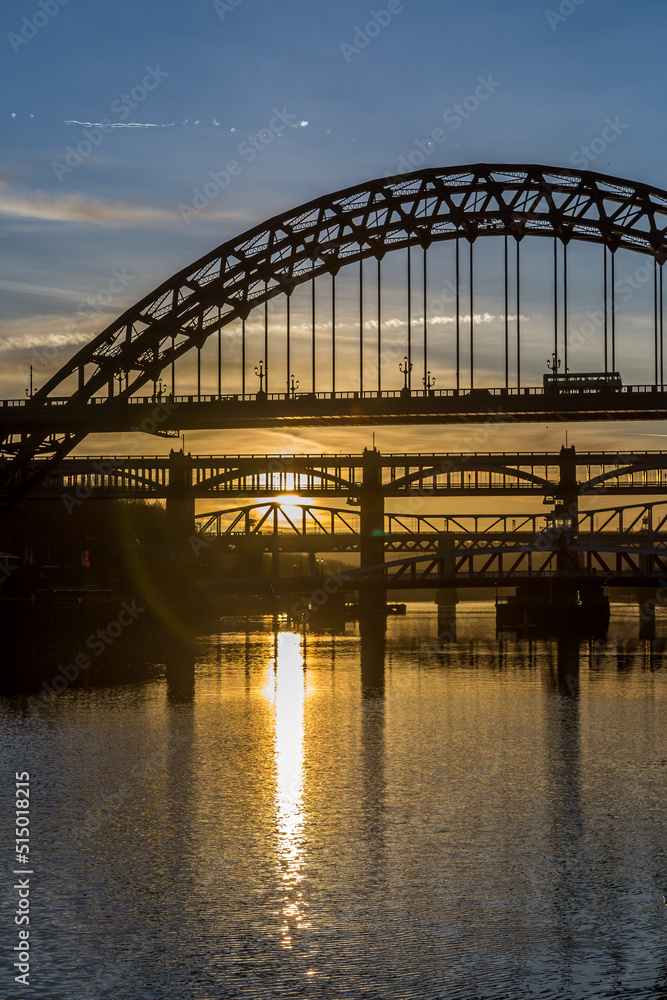 Naklejka premium The Tyne Bridge in Newcastle at sunset, reflecting in the almost still River Tyne beneath