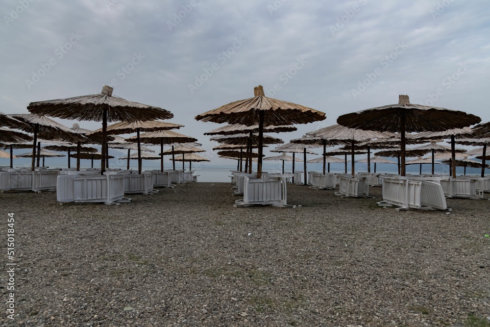 chairs and beach umbrellas at an empty sand beach at Lake Ohrid