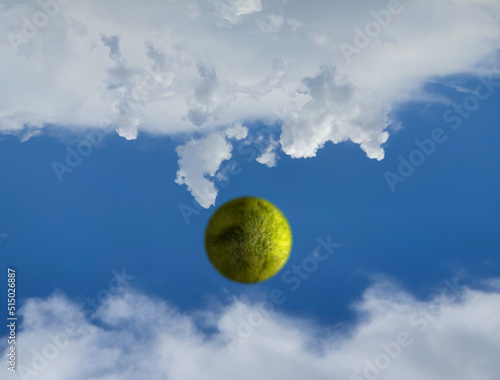 Esfera de hierva emulando a pelota de golf lanzada al cielo hacia las nubes
