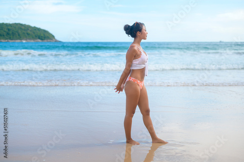Young asian woman in bikini doing yoga on the beach, health and meditation concept © tonefotografia