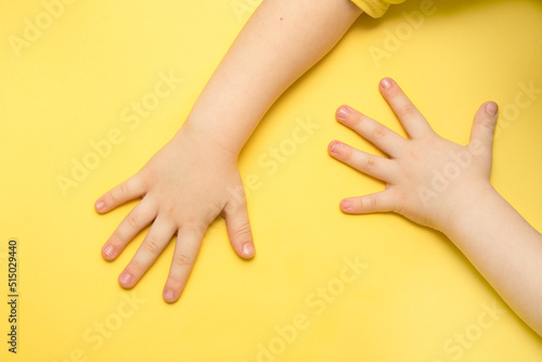 children s hands on a yellow background with copy space