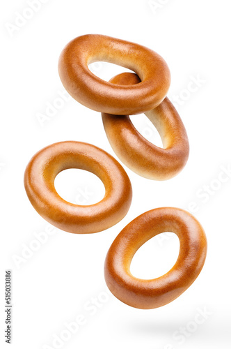 Flying delicious fresh bagels, isolated on white background