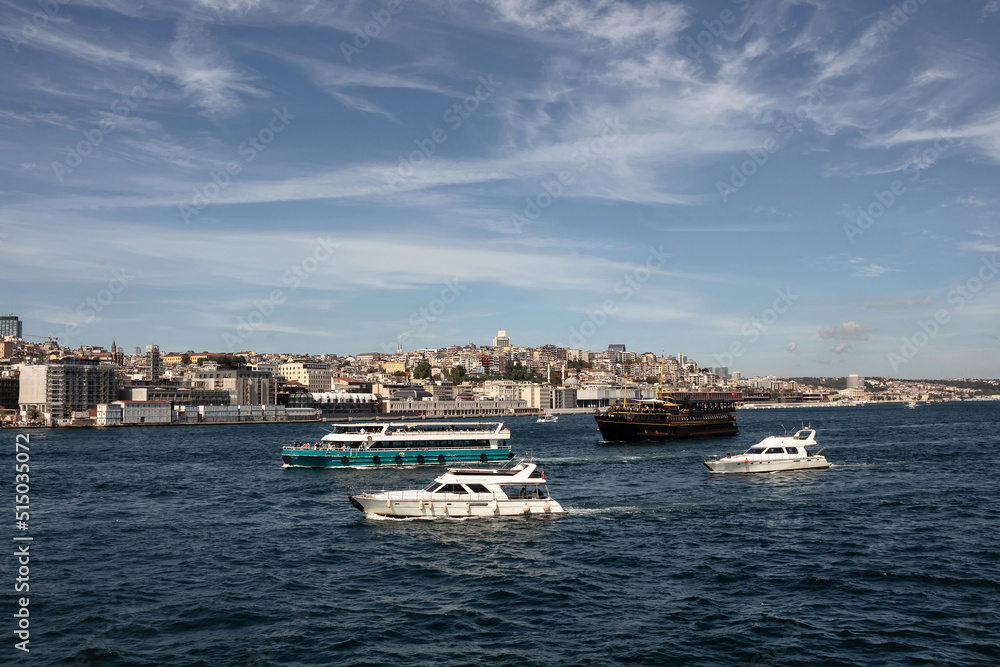 View of tour boats and yachts on Bosphorus in Istanbul. European side is in the view. It is a sunny summer day.
