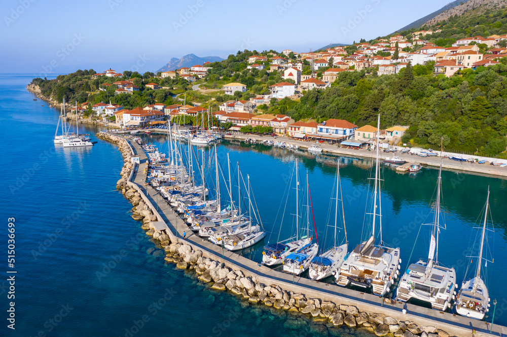 Small marina with catamaran yachts and sailboats in Greece. Kalamos Marina. Beautiful and cozy harbor in Greece. Old fishing village with port on the shore of the Ionian Sea. Travel by boat on the sea