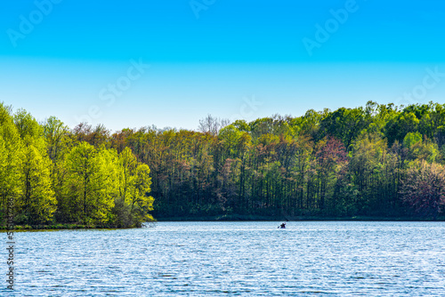 A lone kayaker paddles across the waters of Worster Lake at Potato Creek State Park in North Liberty, Indiana photo