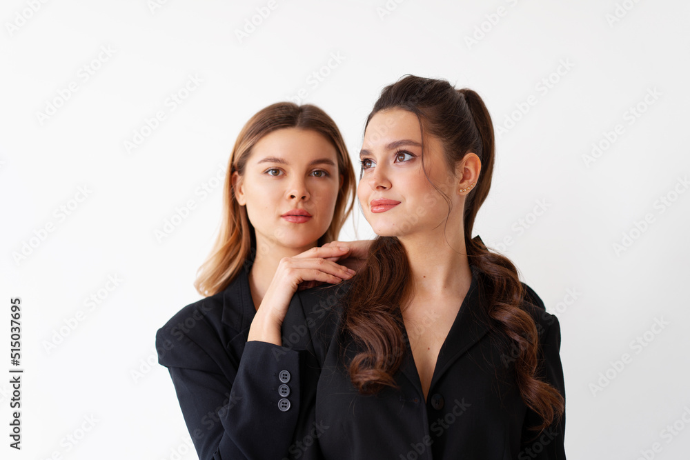 Concept of partnership in business. Two Young businesswoman dressed black formal suit standing studio isolated white background. Concept of partnership in business. Two Young businesswoman dressed black formal suit standing studio isolated white background.