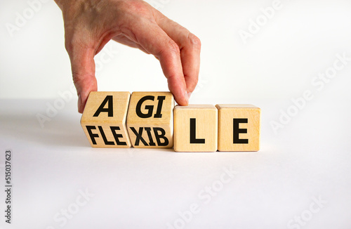 Flexible and agile symbol. Concept words Flexible and agile on wooden cubes. Businessman hand. Beautiful white table white background. Business flexible and agile concept. Copy space.