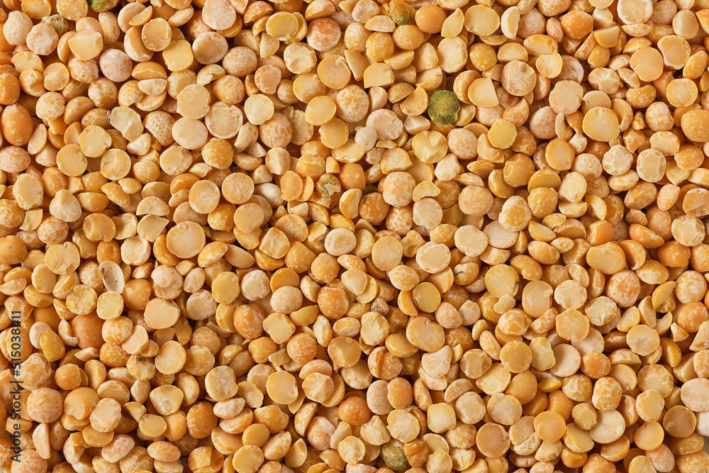 A background of split yellow peas. dry pea grains abstract food background. dried peas texture A background of split yellow peas. dry pea grains abstract food background. dried peas texture