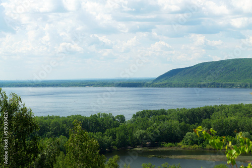 lake and mountains in the summer.beautiful view from the top of the mountain. cloud sky over green hills with blue river