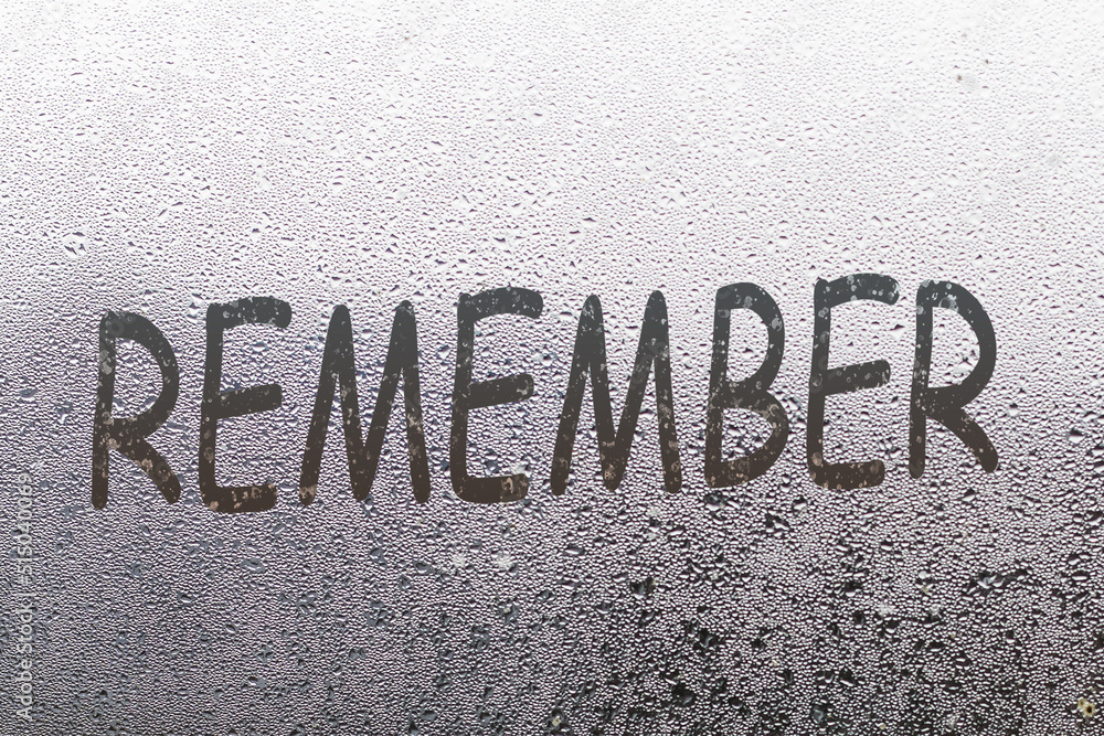 Foggy glass on window with written finger word remember overcast wet window Foggy glass on window with written finger word remember overcast wet window