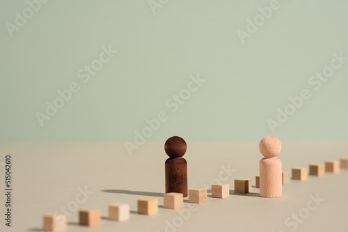 Racial diversity, inclusion and equality concept photo illustration. Two figures facing one another with a barrier. Human rights, equal opportunity and overcoming adversity in organizations. photo