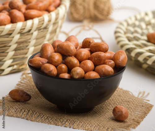 peanut kri kri served in a bowl isolated on napkin side view of nuts on grey background