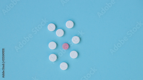 White and pink pills on a blue background.