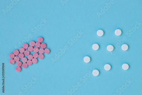White and pink pills on a blue background.