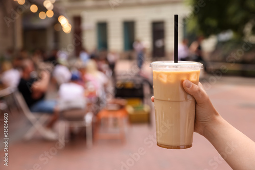 Woman holding takeaway plastic cup with cold coffee drink outdoors  closeup. Space for text