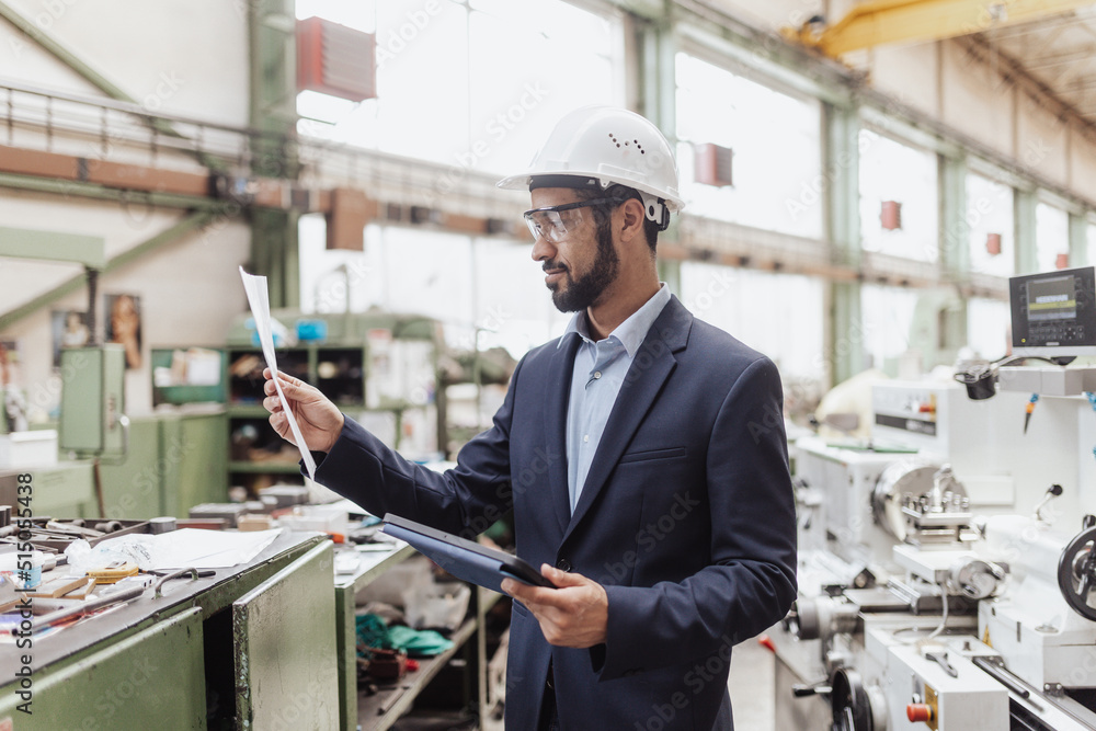 Engineering manager doing routine check up in industrial factory Engineering manager doing routine check up in industrial factory
