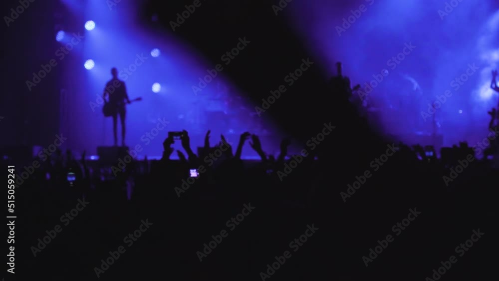 Audience crowd many people fans clap hands applaud enjoy live music festival concert event concept rock band silhouettes performance sing on night club outdoor stage in purple light, slow motion Audience crowd many people fans clap hands applaud enjoy live music festival concert event concept rock band silhouettes performance sing on night club outdoor stage in purple light, slow motion