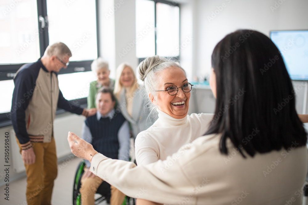 Obraz premium Happy senior women students meeting and hugging in classroom.
