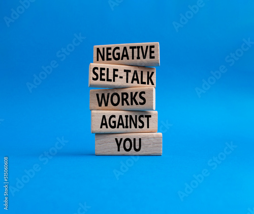 Negative self-talk works against you symbol. Concept words Negative self-talk works against you on wooden blocks. Beautiful blue background. Psychological concept. Copy space