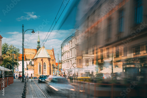 Krakow, Poland. Trams Motion Near Dominican Square. Traffic And Franciscan Monastery and Basilica of St. Francis of Assisi On Background. photo