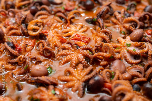 Octopuses are cooked with tomato, olives.Octopus Guazzetto,octopus Luciana ,moscardini in umido, typical Italian Recipe photo