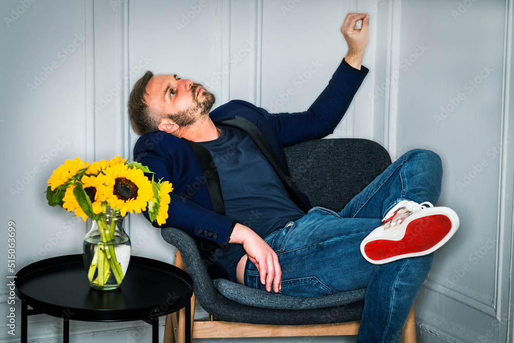 Young tired man with beard, relaxing, thinking inside at home in New York City,