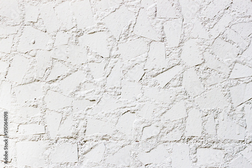 White wall decorated with tiles pieces close-up. Abstract background