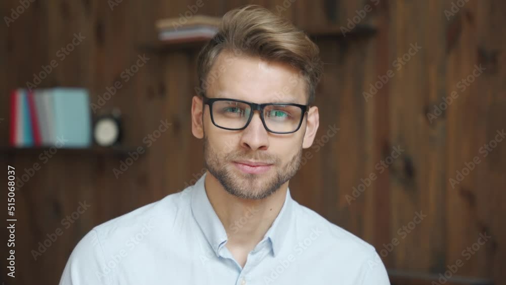 Confident young adult businessman wearing glasses looking at camera in office, charming millennial professional, male small owner, coach, leader, entrepreneur headshot face front close up portrait. Confident young adult businessman wearing glasses looking at camera in office, charming millennial professional, male small owner, coach, leader, entrepreneur headshot face front close up portrait.