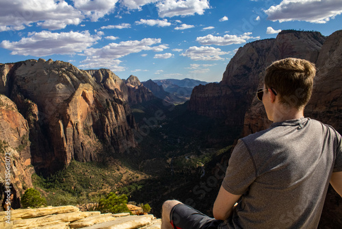 Φωτογραφία Man wearing sunglasses looking over green and steep canyon in Zion National Park