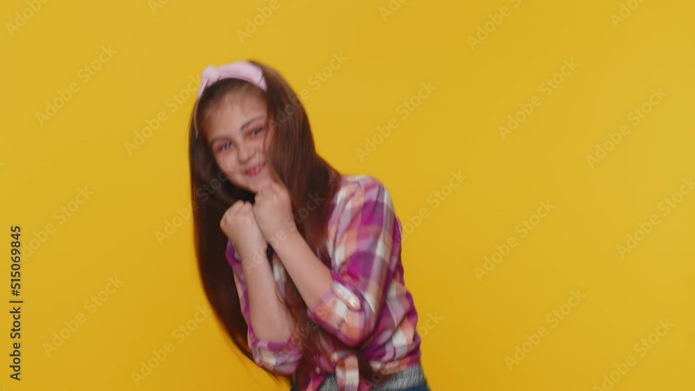Aggressive preteen child girl kid making fight threat at camera, shaking fist punch, boxing with expression, punishment practicing exercises negative rage. Little toddler children on yellow background Aggressive preteen child girl kid making fight threat at camera, shaking fist punch, boxing with expression, punishment practicing exercises negative rage. Little toddler children on yellow background