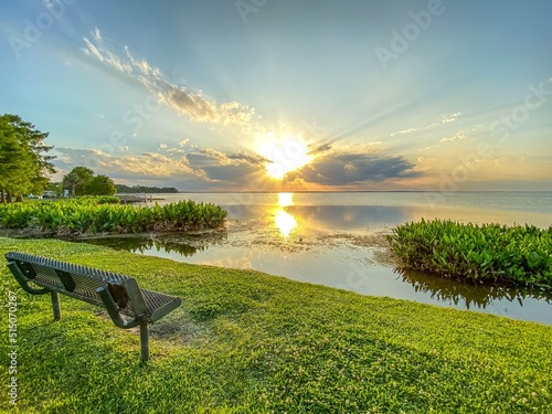 Park bench with view of brilliant sunset at Newton Park on Lake Apopka at Winter Garden, Florida